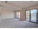 Spacious living room with plush carpet and sliding glass doors leading to a balcony at 3515 S Dawson St, Aurora, CO 80014