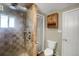 Shower room with tiled rainfall shower and hand wand, and open door to the adjacent toilet room at 2415 Chase St, Edgewater, CO 80214