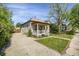 Quaint home with a covered porch, nice lawn, and a long driveway, providing a welcoming curb appeal at 2415 Chase St, Edgewater, CO 80214