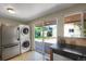 Kitchen features a stainless steel refrigerator and stacked washer/dryer near sliding glass doors to backyard at 2415 Chase St, Edgewater, CO 80214