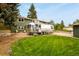 Spacious lawn with vintage Airstream, complementing the charming green two-story home at 403 Anderson St, Castle Rock, CO 80104