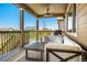 Relaxing covered back porch with comfortable seating and ceiling fan at 22891 E Union Cir, Aurora, CO 80015