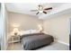 Neutral bedroom featuring a ceiling fan, carpeted floors, and lamps on each side of the bed at 22891 E Union Cir, Aurora, CO 80015