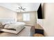 Comfortable bedroom offers a ceiling fan, mounted TV, and natural light, promoting relaxation at 22891 E Union Cir, Aurora, CO 80015
