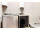 Contemporary laundry room boasting new stainless-steel washer and dryer units and white cabinets at 22891 E Union Cir, Aurora, CO 80015