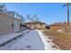 Sunny backyard with snow, a detached garage, and a fenced perimeter at 2584 S Utica St, Denver, CO 80219