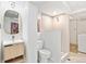 Modern bathroom features sleek vanity, gold mirror, and glass-enclosed tiled shower, plus a convenient washer and dryer at 1335 Jasmine St, Denver, CO 80220