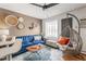 Bright living room with blue velvet sofa, unique swing chair and decorative woven wall art at 1833 N Williams St # 201, Denver, CO 80218