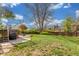 Expansive backyard with a well-maintained lawn, patio, and mature trees, perfect for outdoor activities at 3841 W Quinn Pl, Denver, CO 80236