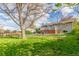 Lush backyard featuring a spacious lawn, mature trees, and a charming wooden deck, great for relaxation at 3841 W Quinn Pl, Denver, CO 80236