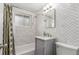 Bathroom featuring tub shower, marble tile surround, and vanity sink at 3841 W Quinn Pl, Denver, CO 80236