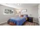 Cozy bedroom featuring a comfortable bed, wood floors, and a bright window providing natural light at 3841 W Quinn Pl, Denver, CO 80236