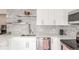 Modern kitchen with white cabinets, chevron backsplash, stainless steel appliances, and quartz countertops at 3841 W Quinn Pl, Denver, CO 80236