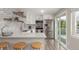 Bright kitchen with stainless steel appliances, bar seating, white cabinets and a sliding door to the outside at 3841 W Quinn Pl, Denver, CO 80236