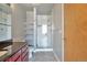 Bathroom featuring a single vanity with granite countertop, tiled floors, shelving, and a glass-enclosed shower at 1475 Delgany St # 807, Denver, CO 80202