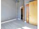 Bright bedroom featuring wood-look tile floors, high ceilings, gray walls and a door leading to the bathroom at 1475 Delgany St # 807, Denver, CO 80202