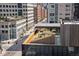Rooftop view overlooking a city street with modern buildings, tree-lined sidewalks, and outdoor seating areas at 1475 Delgany St # 807, Denver, CO 80202