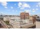 An elevated cityscape view of buildings, street and railroad tracks on a partly cloudy day at 1475 Delgany St # 807, Denver, CO 80202