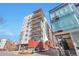 Modern condo building with large balconies, steel accents and brickwork against a clear blue sky at 1475 Delgany St # 807, Denver, CO 80202