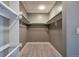 Spacious walk-in closet with built-in shelving and light grey wood-look tile floors at 1475 Delgany St # 807, Denver, CO 80202