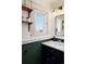 Bathroom boasts a black vanity, white countertop, wood shelves, and a bright window at 5103 Quitman St, Denver, CO 80212
