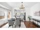 Stylish dining area with chandelier, hardwood floors, and seamless connection to the updated kitchen at 5103 Quitman St, Denver, CO 80212