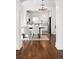 Elegant dining area with chandelier, hardwood floors, and a view into the modern, adjacent kitchen at 5103 Quitman St, Denver, CO 80212