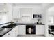 Well-equipped kitchen with sleek black appliances, white cabinets, and a functional design for culinary enthusiasts at 5103 Quitman St, Denver, CO 80212