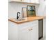 Close-up of the wet bar in the basement with wood countertop, black sink and beverage cooler at 5103 Quitman St, Denver, CO 80212