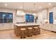 Bright kitchen features a large island with counter seating, modern appliances, and beautiful light wood floors at 1120 S Gaylord St, Denver, CO 80210
