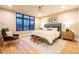 Cozy bedroom with a queen-sized bed, soft lighting, large window, and hardwood floors at 1120 S Gaylord St, Denver, CO 80210
