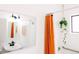 This is a bathroom, with black fixtures, white subway tiles, orange shower curtain, and hanging plant, creating a fresh look at 3890 Moore St, Wheat Ridge, CO 80033