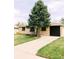 Attractive brick home featuring a well-maintained lawn, mature evergreen, and inviting curb appeal at 3890 Moore St, Wheat Ridge, CO 80033
