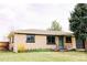 Charming one-story home boasts an appealing brick facade and a lush green lawn at 3890 Moore St, Wheat Ridge, CO 80033