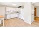 Bright white kitchen with wood floors and stainless steel appliances at 3890 Moore St, Wheat Ridge, CO 80033