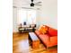 Cozy living room featuring hardwood floors, a comfortable orange sofa, and a modern console table for a bright, inviting space at 3890 Moore St, Wheat Ridge, CO 80033