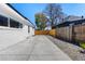 A partially fenced backyard showing a large concrete pad and rock landscaping at 4745 N Clay St, Denver, CO 80211