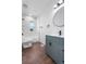Modern bathroom featuring stylish vanity, round mirror, and a window offering natural light over the bathtub at 4745 N Clay St, Denver, CO 80211