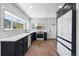 Well-lit kitchen with dark cabinets, stainless steel appliances, and subway tile backsplash, with an adjacent entrance at 4745 N Clay St, Denver, CO 80211