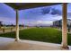Wide backyard with green grass, wooden fence and a fire pit under a purple and blue sky at 38 Morgan Cir, Erie, CO 80516