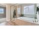 This bright bathroom showcases a glass-enclosed shower and soaking tub next to the window and a plant at 38 Morgan Cir, Erie, CO 80516