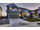 Charming two-story home boasts a gray exterior, two-car garage, and well-manicured lawn at 38 Morgan Cir, Erie, CO 80516