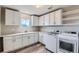 Well-equipped laundry room featuring modern washer and dryer, storage cabinets, and countertop space at 38 Morgan Cir, Erie, CO 80516
