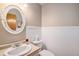 Half bathroom featuring wainscoting, cream walls, and a decorative mirror at 9640 Moss Rose Cir, Highlands Ranch, CO 80129