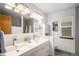 Bright bathroom boasts double vanity, ample lighting, and modern finishes at 9640 Moss Rose Cir, Highlands Ranch, CO 80129