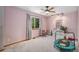 Bright bedroom with a large window, ceiling fan, and neutral carpet, creating a cozy and inviting space at 9640 Moss Rose Cir, Highlands Ranch, CO 80129