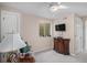 Cozy bedroom featuring neutral walls, wall-mounted TV, and a comfortable floral armchair at 9640 Moss Rose Cir, Highlands Ranch, CO 80129