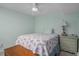 Bright bedroom with fresh blue walls featuring a bed, ceiling fan, and vintage dresser at 9640 Moss Rose Cir, Highlands Ranch, CO 80129