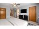 Bright bedroom with neutral walls, television, modern dresser, and carpet at 9640 Moss Rose Cir, Highlands Ranch, CO 80129