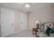 Cozy bedroom featuring neutral walls and carpet, with two doors and a comfortable floral armchair at 9640 Moss Rose Cir, Highlands Ranch, CO 80129